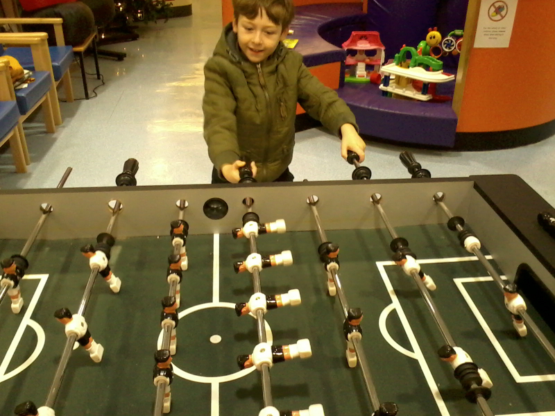 Mason playing table football at Great Ormond Street Hospital whilst waiting for his x-ray.