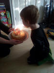 Alfie blowing the candles out on his cake.