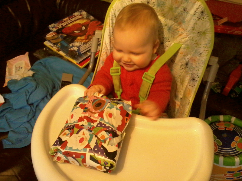 Alfie opens his first ever Christmas present.