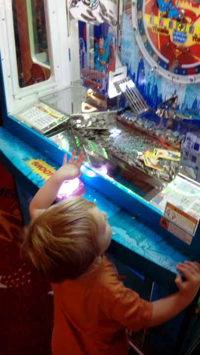 Alfie watching one of the machines on Felixstowe Pier in amazement.