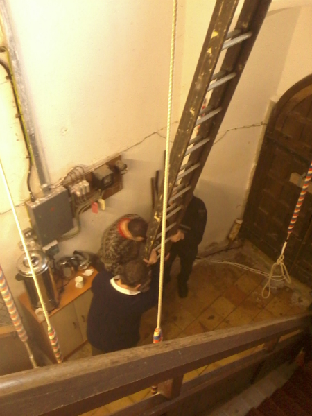 Mervyn Scase prepares to climb a ladder to guide through the new treble at Copdock at the South-East District Practice, with his brother Robert and Jonathan Williamson holding the ladder!