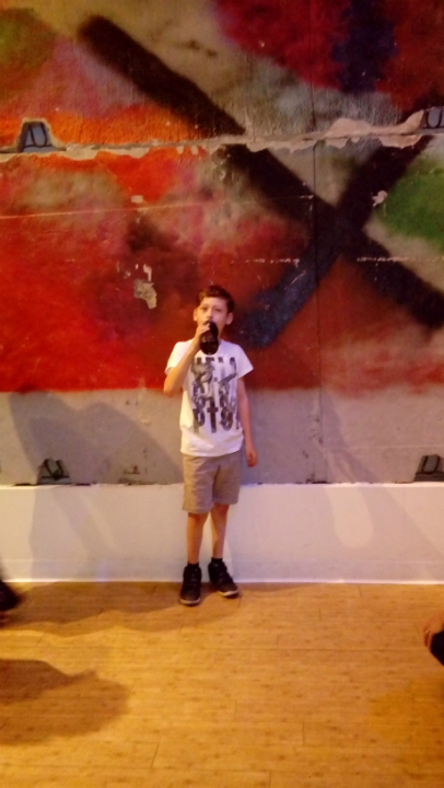 Mason in front of a chunk of the Berlin Wall.