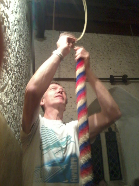 Mike Whitby trying to adjust the treble rope at Earl Soham for the South-East District Practice as Caroline Goodchild and Pippa Moss watch on.